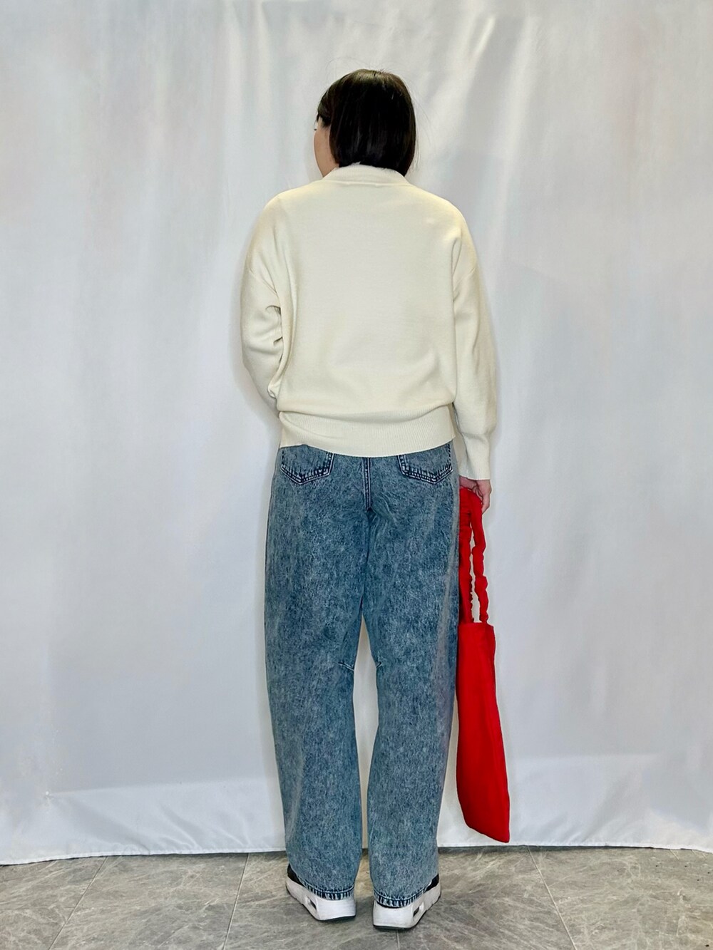 ブルー系のその他パンツ、レッド系のトートバッグ、ホワイト系のニット/セーターを着用したレディースの冬コーディネートの3枚目の写真