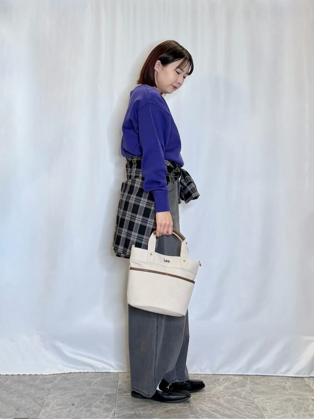 パープル系のニット/セーター、ブラック系のシャツ/ブラウス、ブラック系のデニムパンツを着用したレディースの秋コーディネートの2枚目の写真