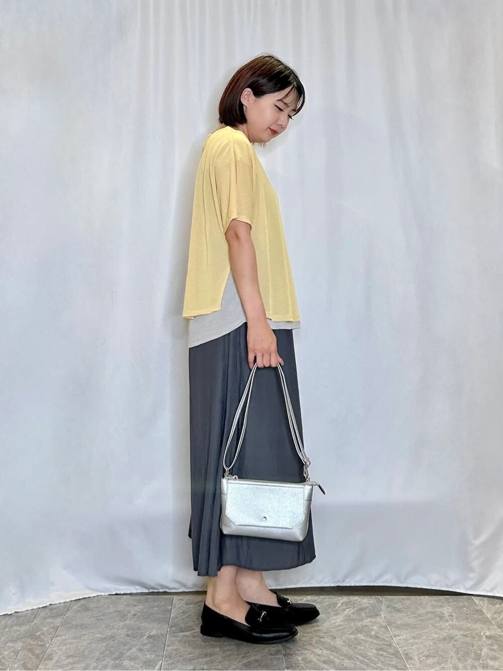 イエロー系のTシャツ/カットソー、グレー系のその他パンツ、ブラック系のその他シューズを着用したレディースの秋コーディネートの2枚目の写真