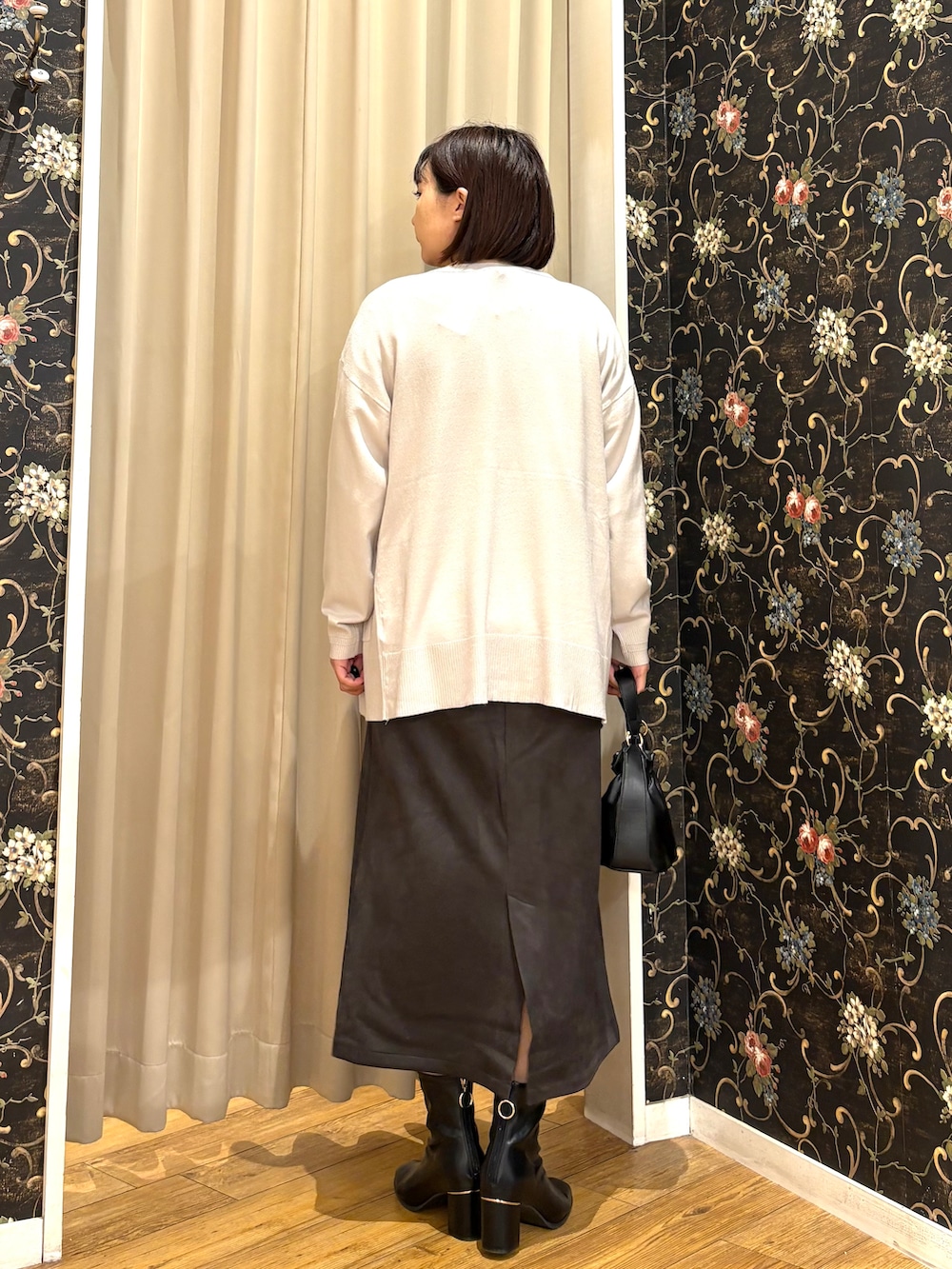 グレー系のカーディガン/ボレロ、オレンジ系のシャツ/ブラウス、グレー系のスカートを着用したレディースの秋コーディネートの3枚目の写真