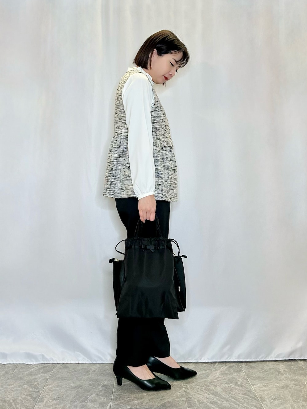 ブラック系のパンプス、ブラック系のトートバッグ、ブラック系のその他パンツを着用したレディースの冬コーディネートの2枚目の写真