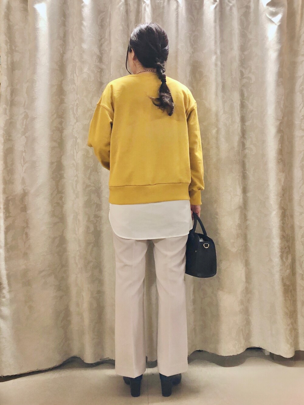 イエロー系のスウェット、ホワイト系のシャツ/ブラウス、ブラック系のブーツを着用したレディースの秋コーディネートの3枚目の写真