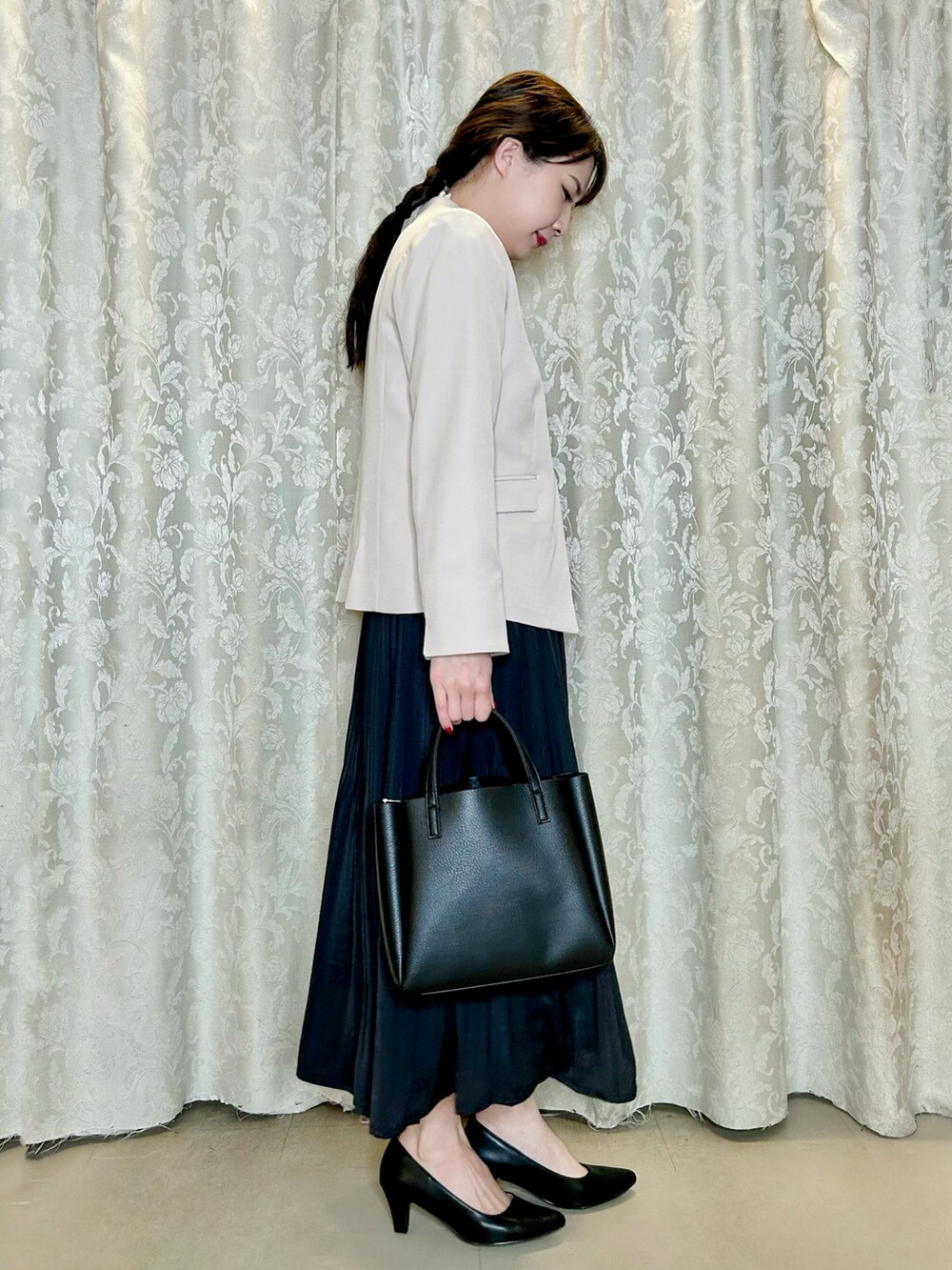 ブラック系のパンプス、ホワイト系のシャツ/ブラウス、ブラック系のスカートを着用したレディースの秋コーディネートの2枚目の写真