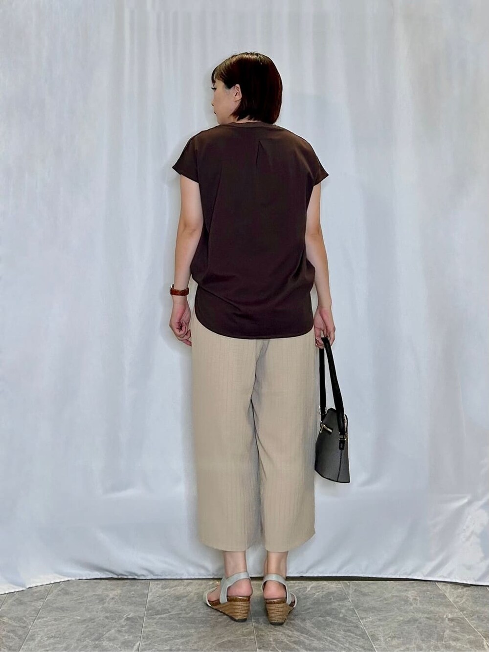 ブラウン系のTシャツ/カットソー、ベージュ系のその他パンツ、シルバー系のサンダルを着用したレディースの夏コーディネートの3枚目の写真