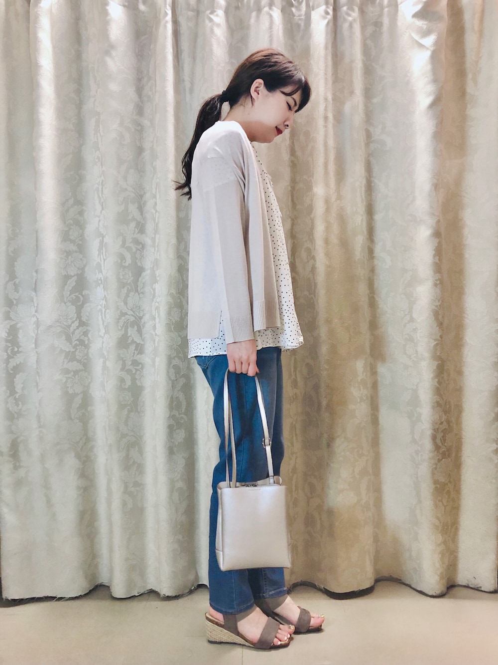 ホワイト系のシャツ/ブラウス、グレー系のカーディガン/ボレロ、ブラウン系のサンダルを着用したレディースの春コーディネートの2枚目の写真