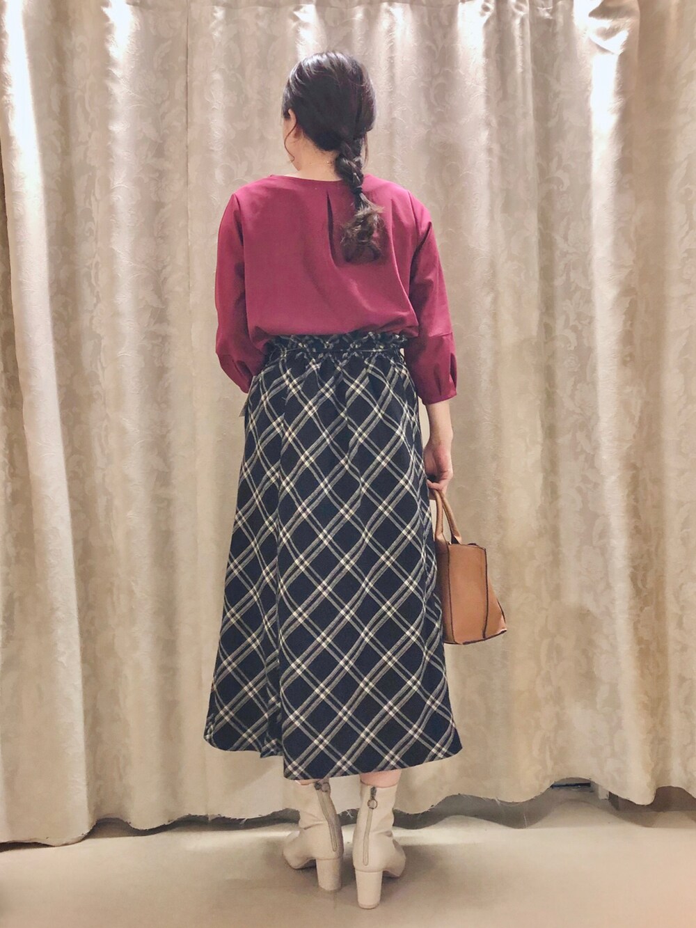 イエロー系のトートバッグ、パープル系のTシャツ/カットソー、ホワイト系のブーツを着用したレディースの秋コーディネートの3枚目の写真