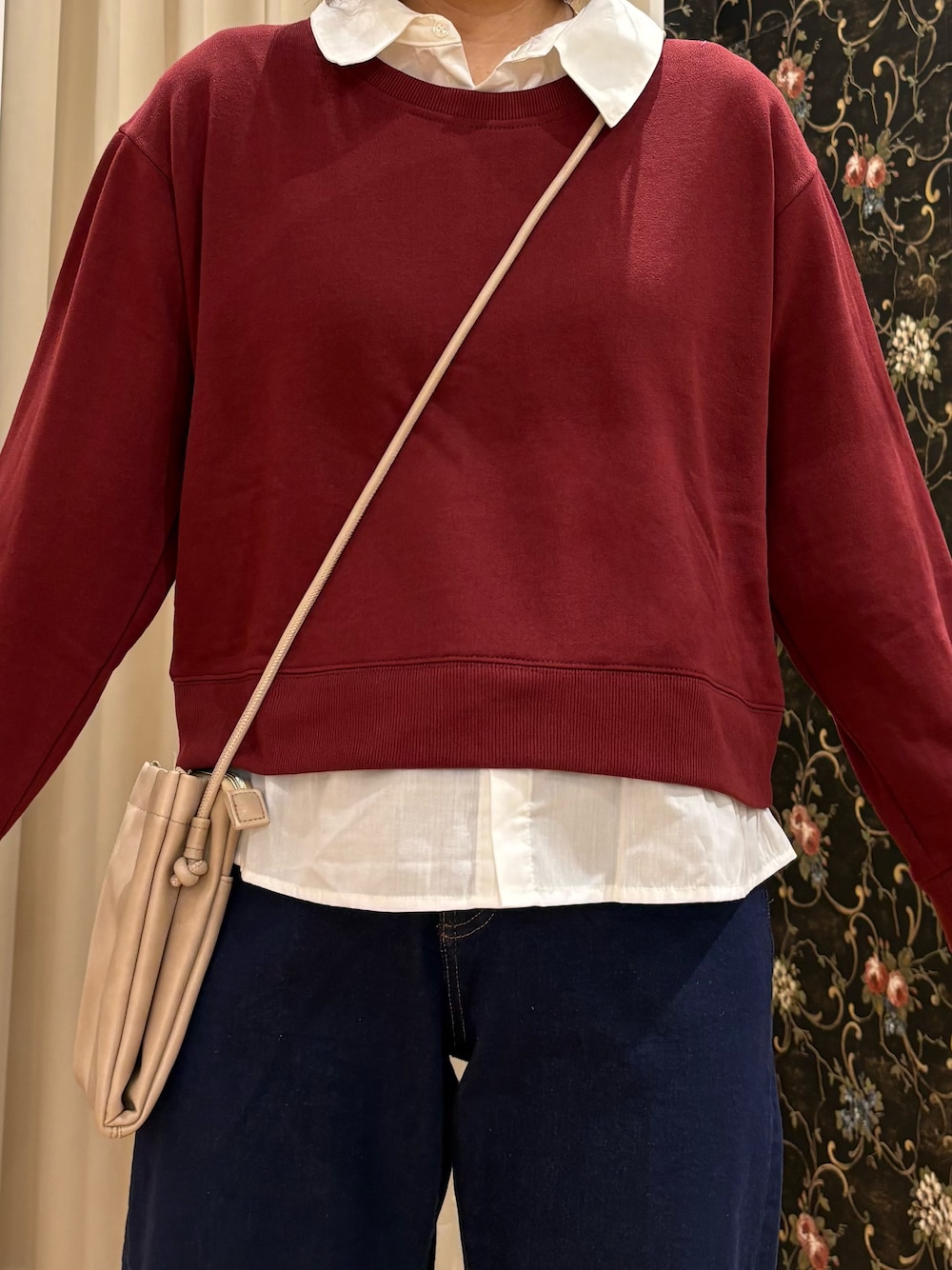 レッド系のTシャツ/カットソー、ブルー系のデニムパンツ、ベージュ系のショルダーバッグを着用したレディースの秋コーディネートの4枚目の写真