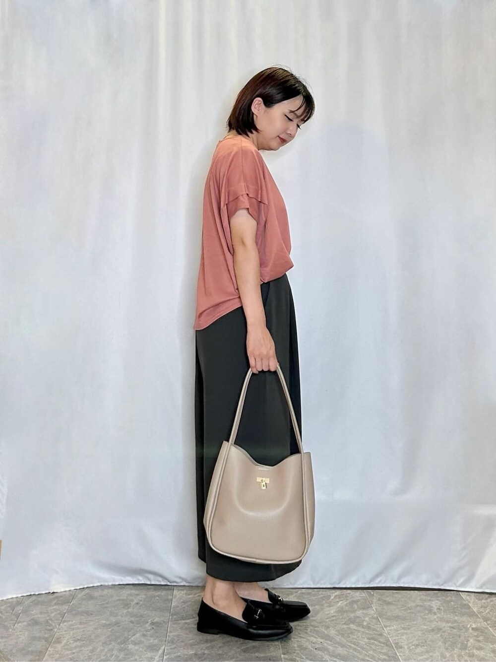 オレンジ系のTシャツ/カットソー、グレー系のその他パンツ、ブラック系のその他シューズを着用したレディースの夏コーディネートの2枚目の写真