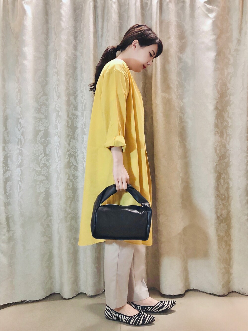 ホワイト系のTシャツ/カットソー、イエロー系のワンピース、ブラック系のパンプスを着用したレディースの春コーディネートの2枚目の写真