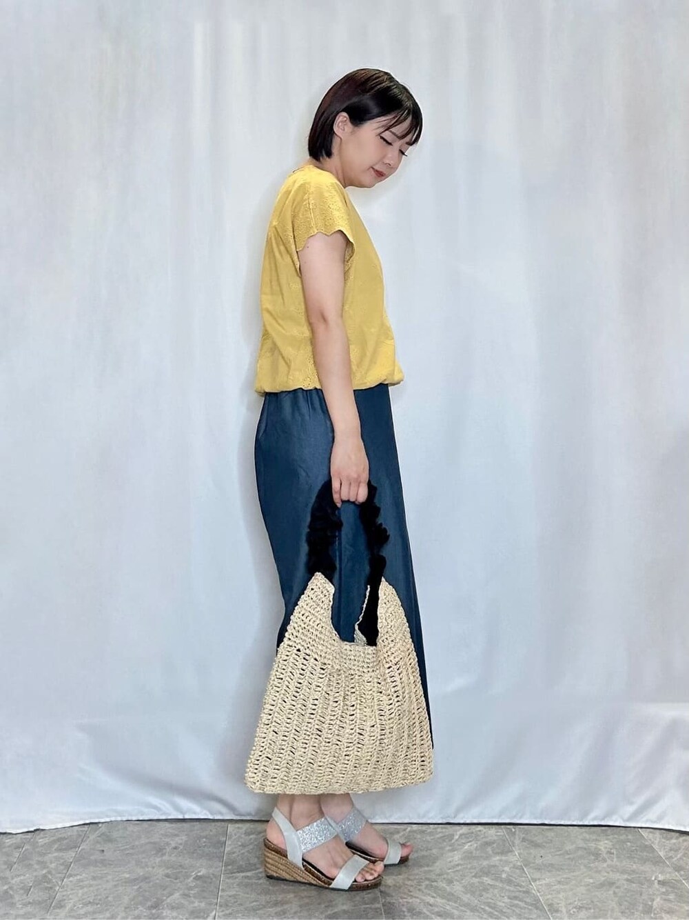 イエロー系のTシャツ/カットソー、ブルー系のデニムパンツ、シルバー系のサンダルを着用したレディースの夏コーディネートの2枚目の写真