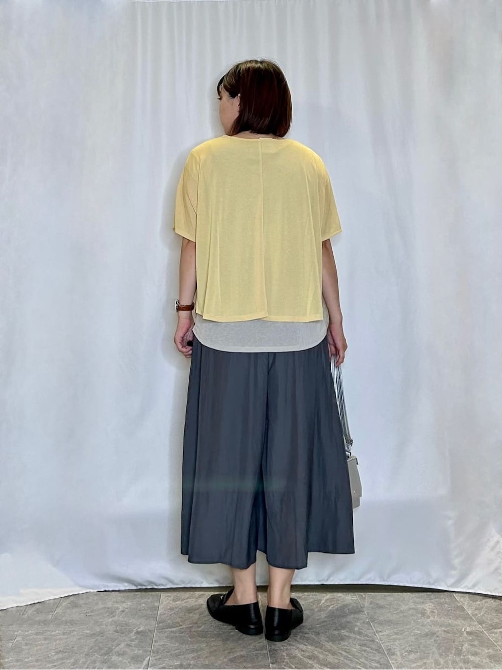 イエロー系のTシャツ/カットソー、グレー系のその他パンツ、ブラック系のその他シューズを着用したレディースの秋コーディネートの3枚目の写真