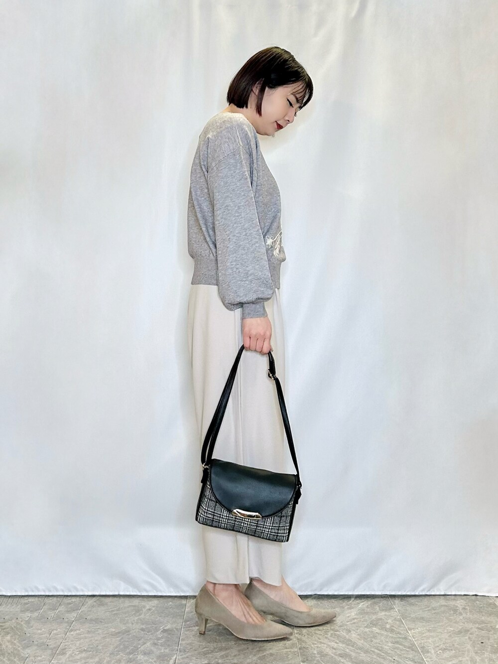 ベージュ系のその他パンツ、ブラック系のショルダーバッグ、ベージュ系のパンプスを着用したレディースの冬コーディネートの2枚目の写真
