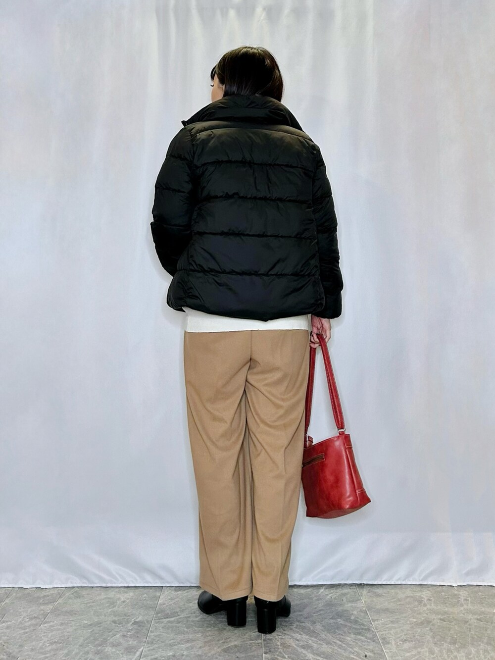 ブラック系のブーツ、レッド系のショルダーバッグ、イエロー系のその他パンツを着用したレディースの冬コーディネートの3枚目の写真