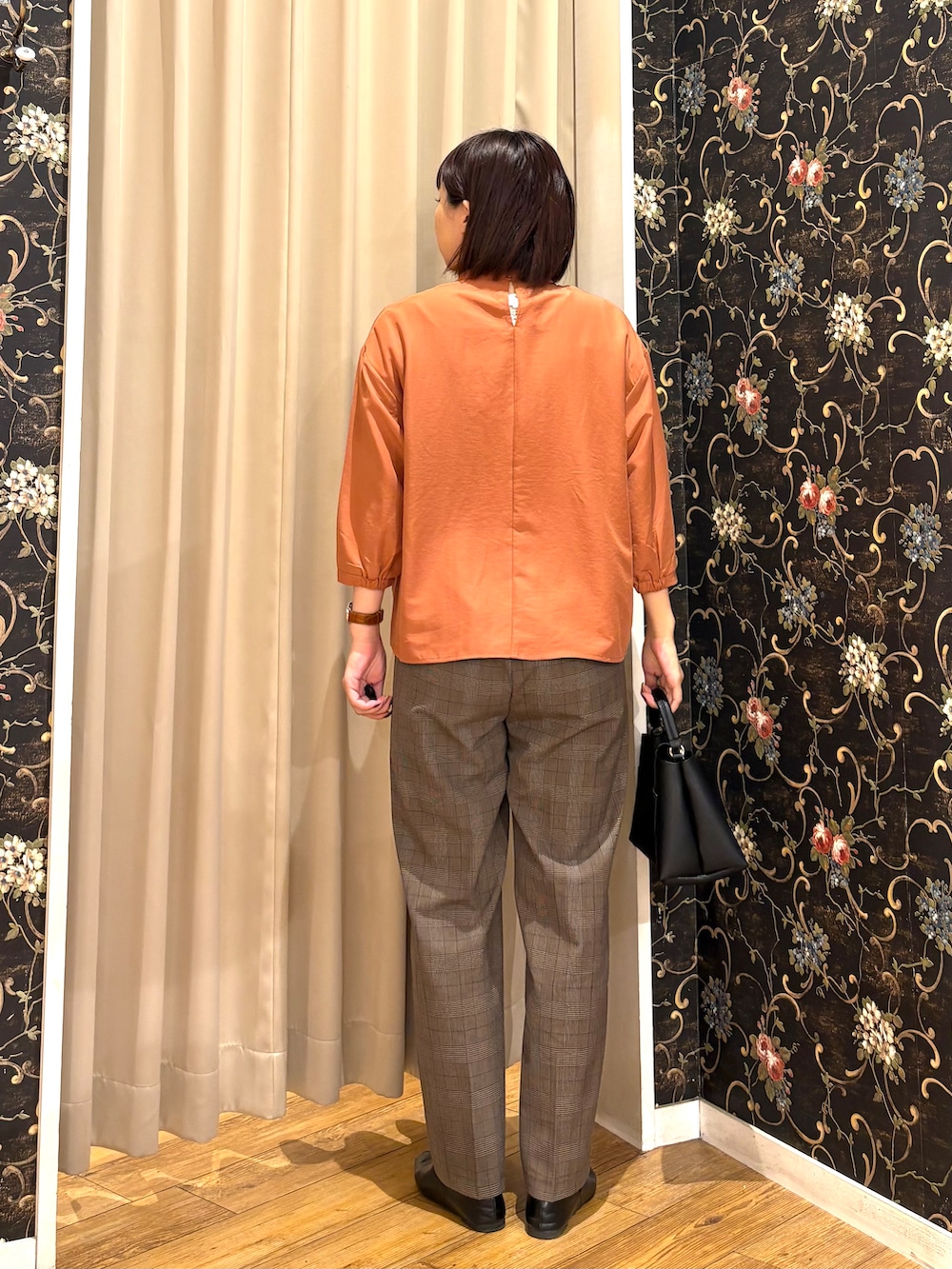 オレンジ系のシャツ/ブラウス、ブラウン系のその他パンツ、ブラック系のショルダーバッグを着用したレディースの秋コーディネートの3枚目の写真