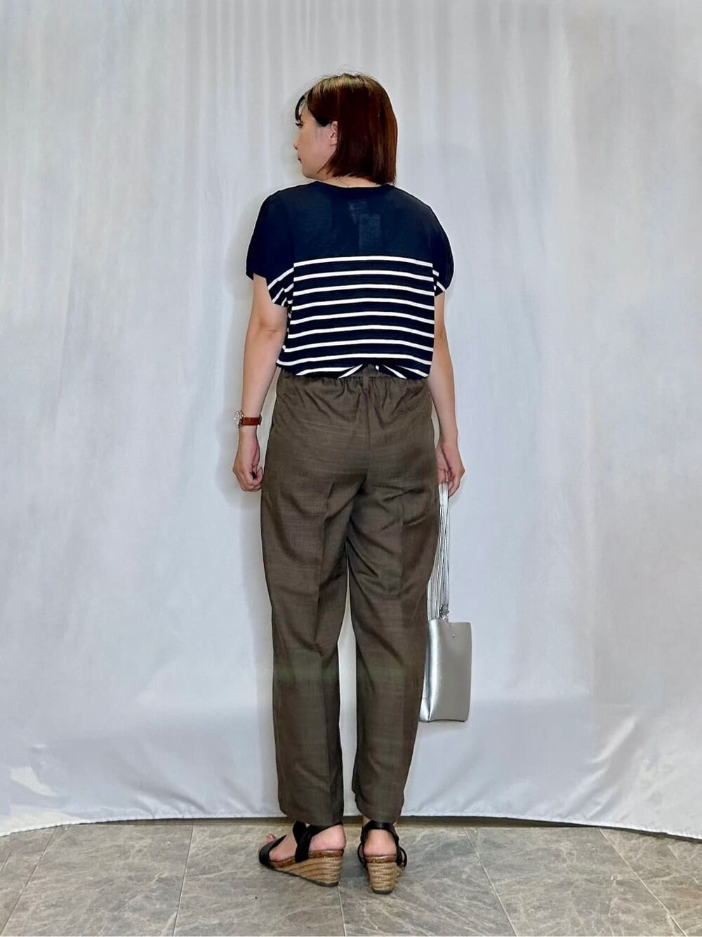 ブルー系のニット/セーター、ブラウン系のその他パンツ、ブラック系のサンダルを着用したレディースの夏コーディネートの3枚目の写真