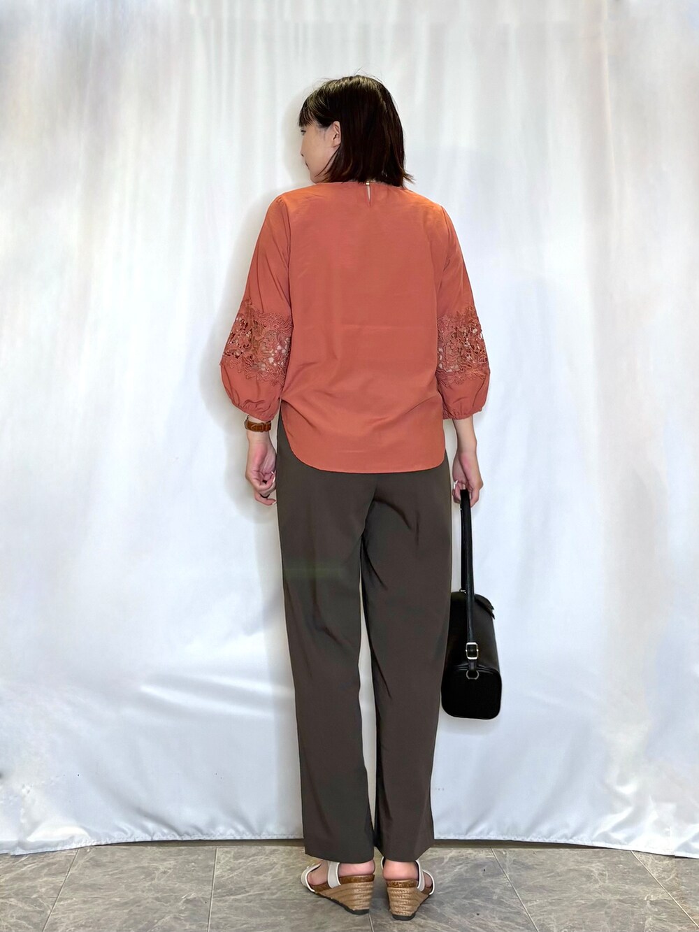 レッド系のシャツ/ブラウス、ブラウン系のその他パンツ、ホワイト系のサンダルを着用したレディースの夏コーディネートの5枚目の写真