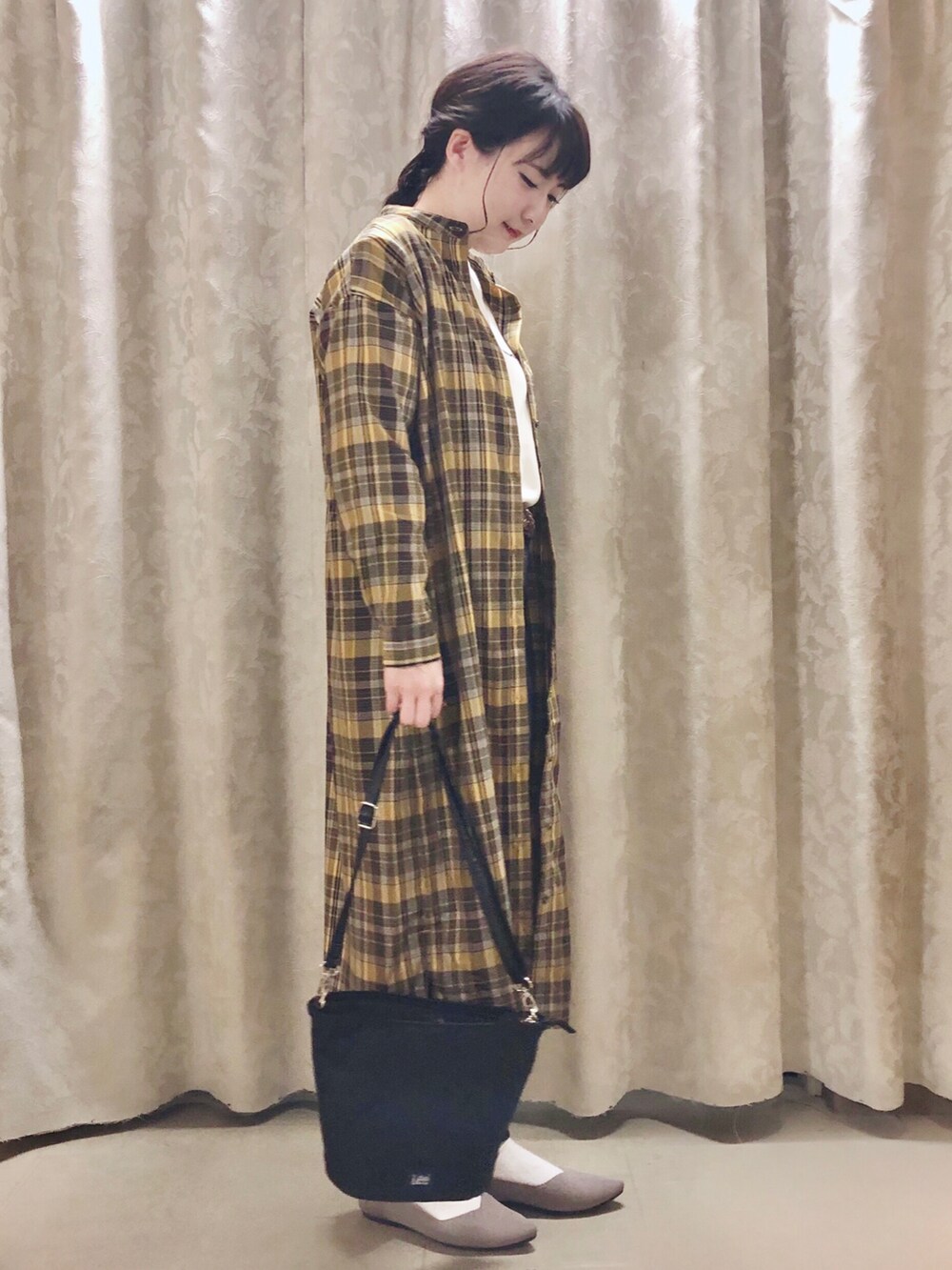 ベージュ系のスウェット、ベージュ系のパンプス、イエロー系のワンピースを着用したレディースの秋コーディネートの2枚目の写真