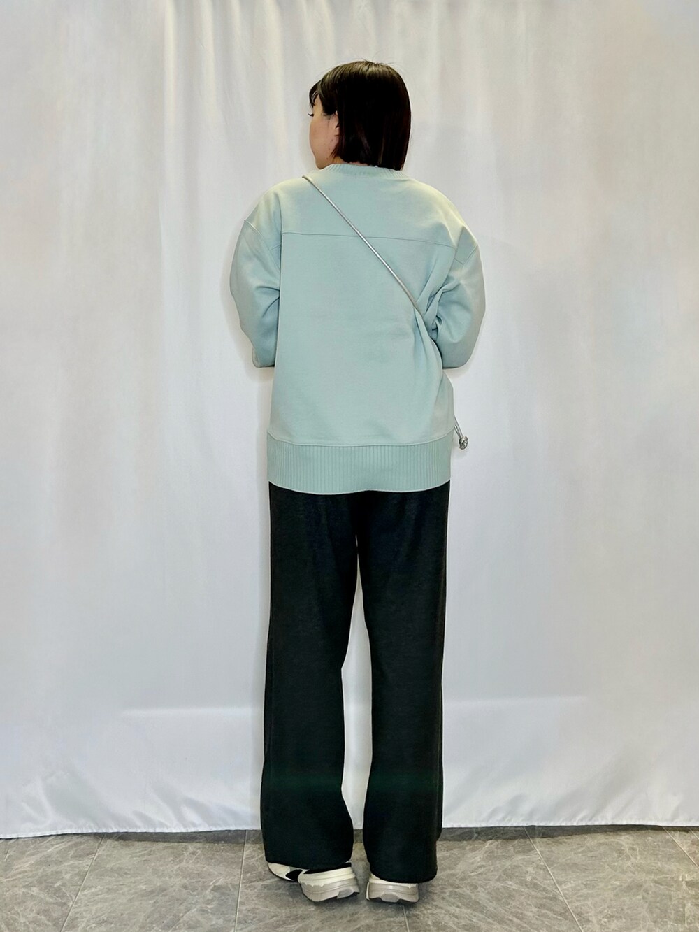 グリーン系のTシャツ/カットソー、ブラック系のその他パンツ、シルバー系のショルダーバッグを着用したレディースの冬コーディネートの3枚目の写真