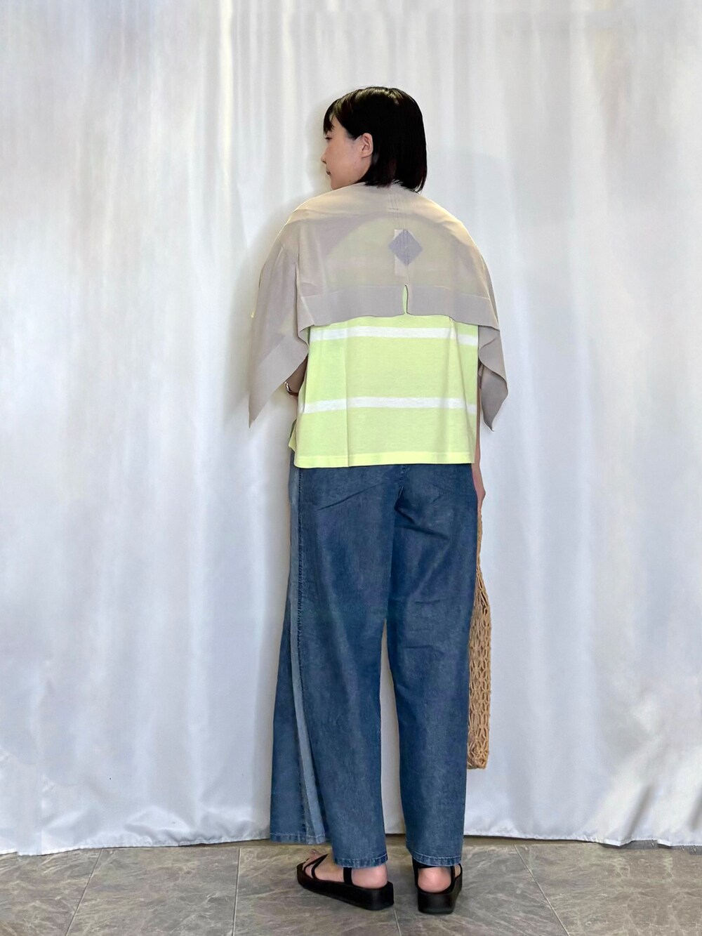 ベージュ系のカーディガン/ボレロ、イエロー系のトートバッグ、ブラック系のサンダルを着用したレディースの春コーディネートの3枚目の写真