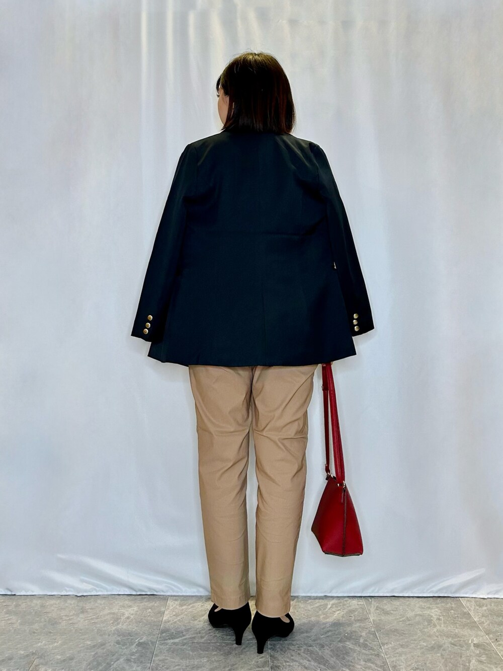 ブルー系のテーラードジャケット、ブラウン系のその他パンツ、レッド系のショルダーバッグを着用したレディースの秋コーディネートの3枚目の写真