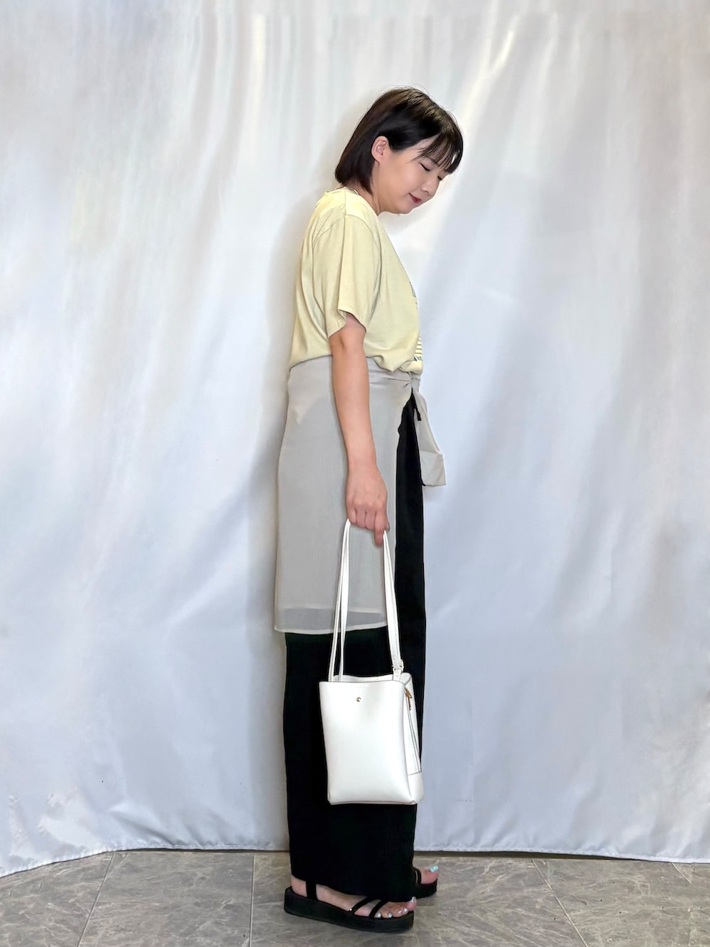 ベージュ系のシャツ/ブラウス、ブラック系のサンダル、ホワイト系のショルダーバッグを着用したレディースの夏コーディネートの2枚目の写真
