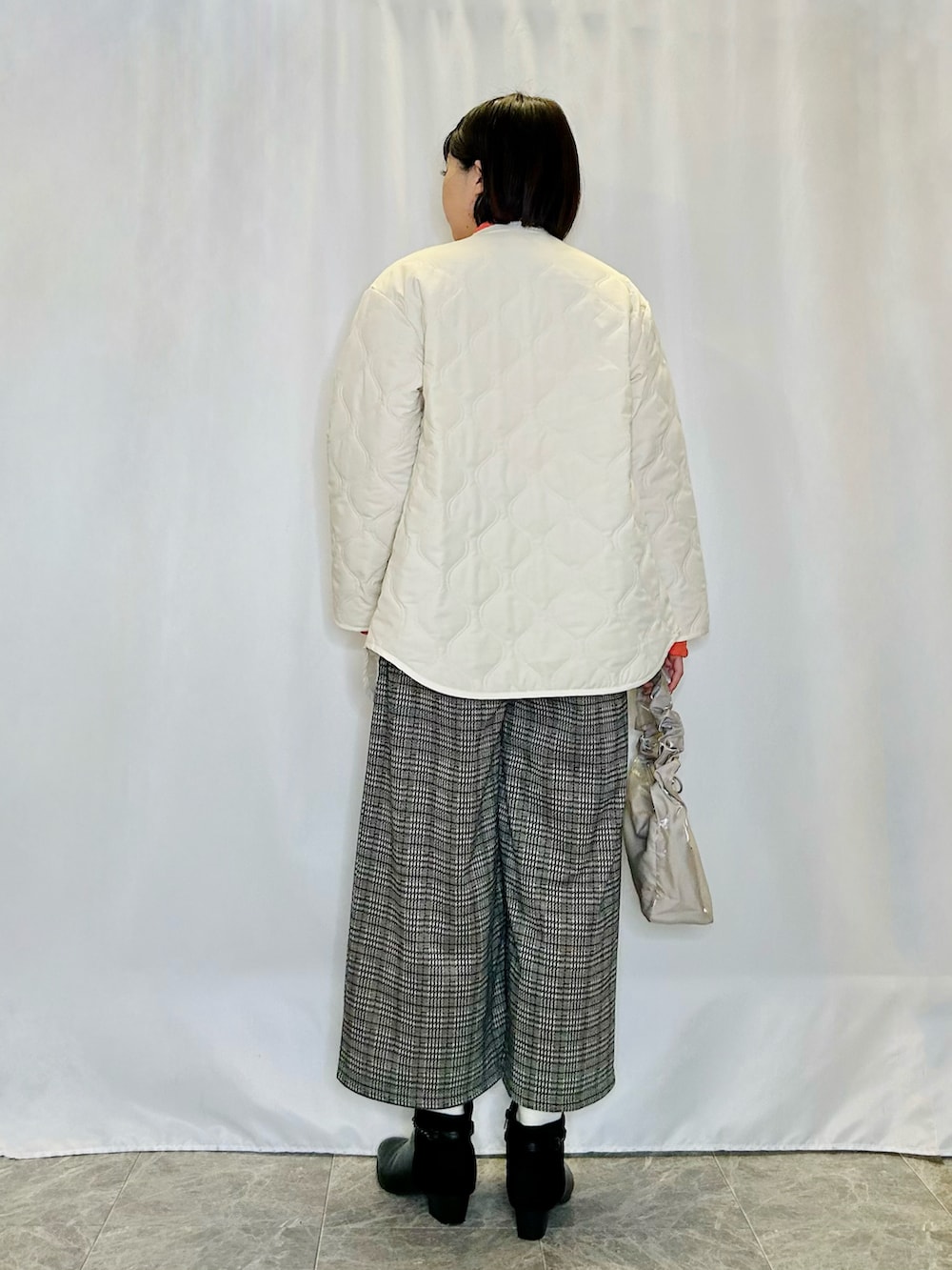 ホワイト系のブルゾン、ベージュ系のその他パンツ、ブラック系のブーツを着用したレディースの冬コーディネートの3枚目の写真