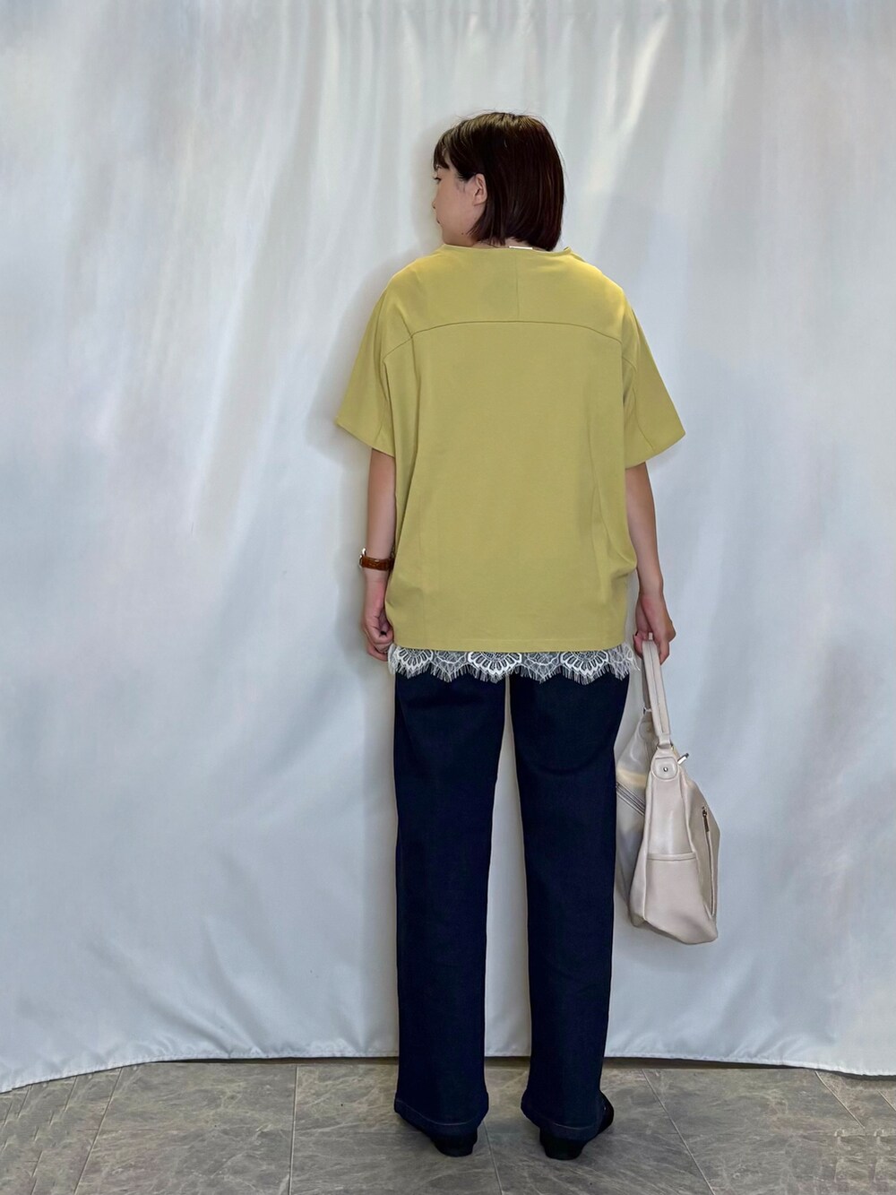 イエロー系のTシャツ/カットソー、ホワイト系のタンクトップ、ブルー系のデニムパンツを着用したレディースの夏コーディネートの5枚目の写真