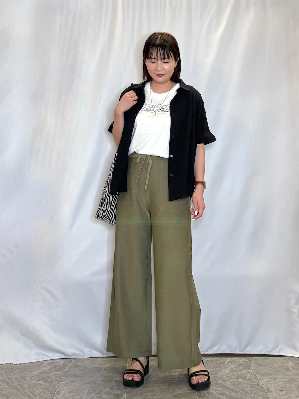 ブラック系のシャツ/ブラウス、ホワイト系のTシャツ/カットソー、グリーン系のその他パンツを着用したレディースの夏コーディネートの2枚目の写真