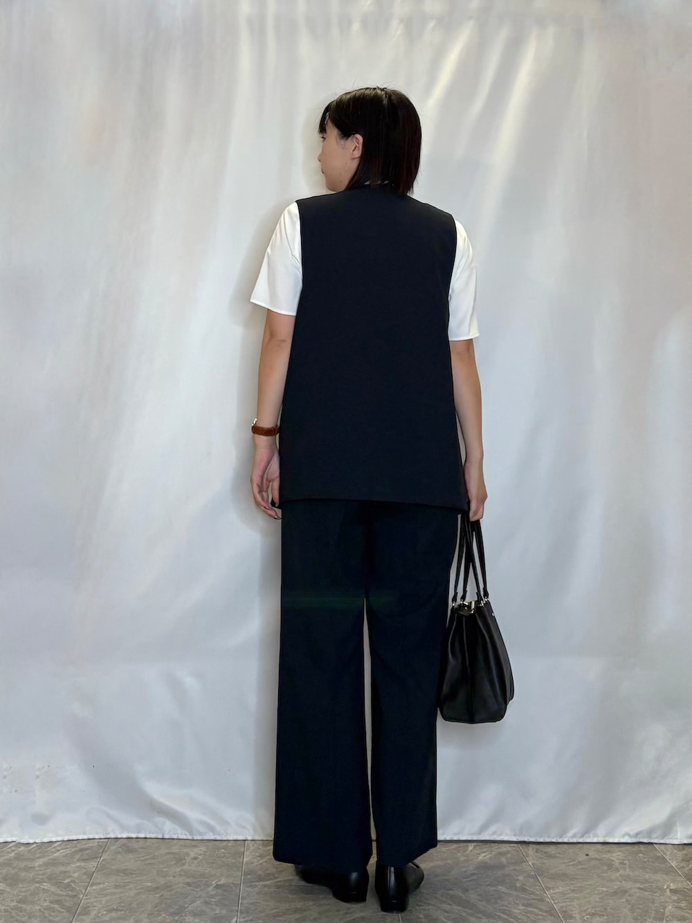 ブラック系のパンプス、ブルー系のその他パンツ、ブルー系のベストを着用したレディースの春コーディネートの3枚目の写真