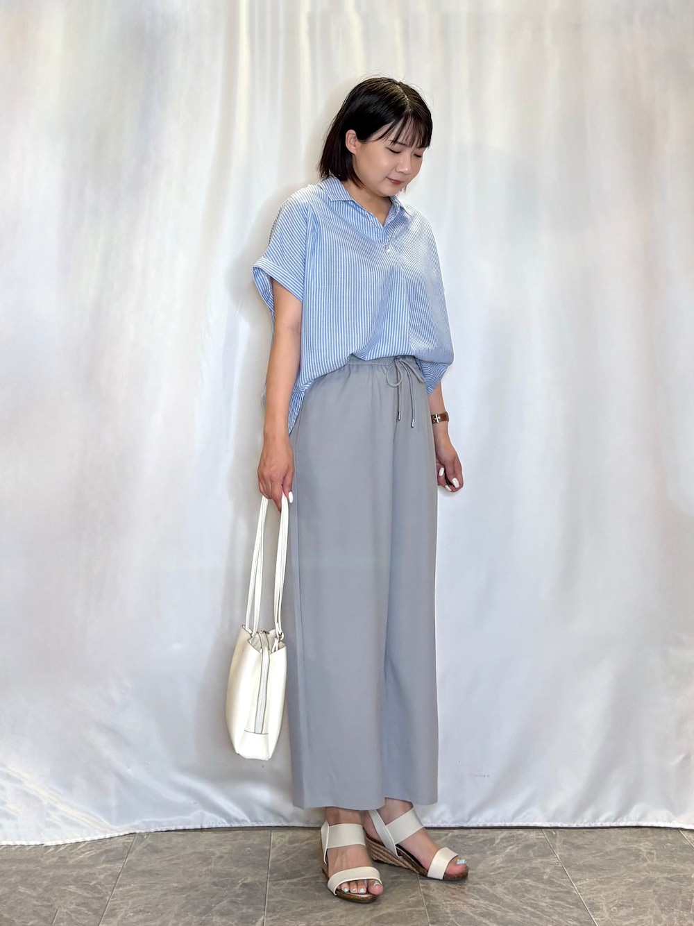 ブルー系のシャツ/ブラウス、グレー系のその他パンツ、ホワイト系のサンダルを着用したレディースの夏コーディネートの3枚目の写真