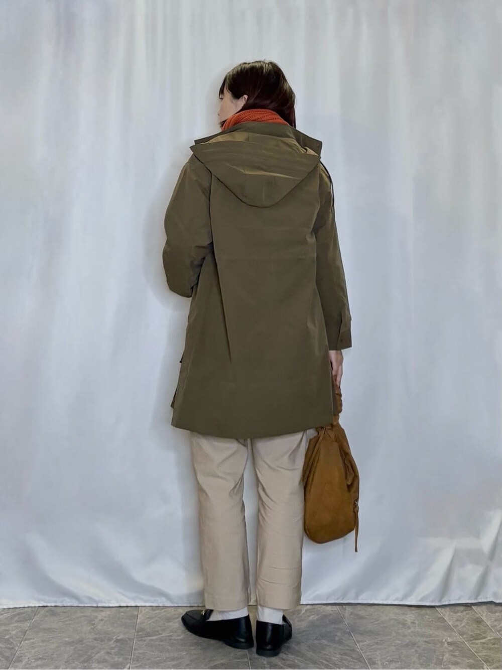 グリーン系のミリタリージャケット、ホワイト系のニット/セーター、ベージュ系のその他パンツを着用したレディースの秋コーディネートの3枚目の写真