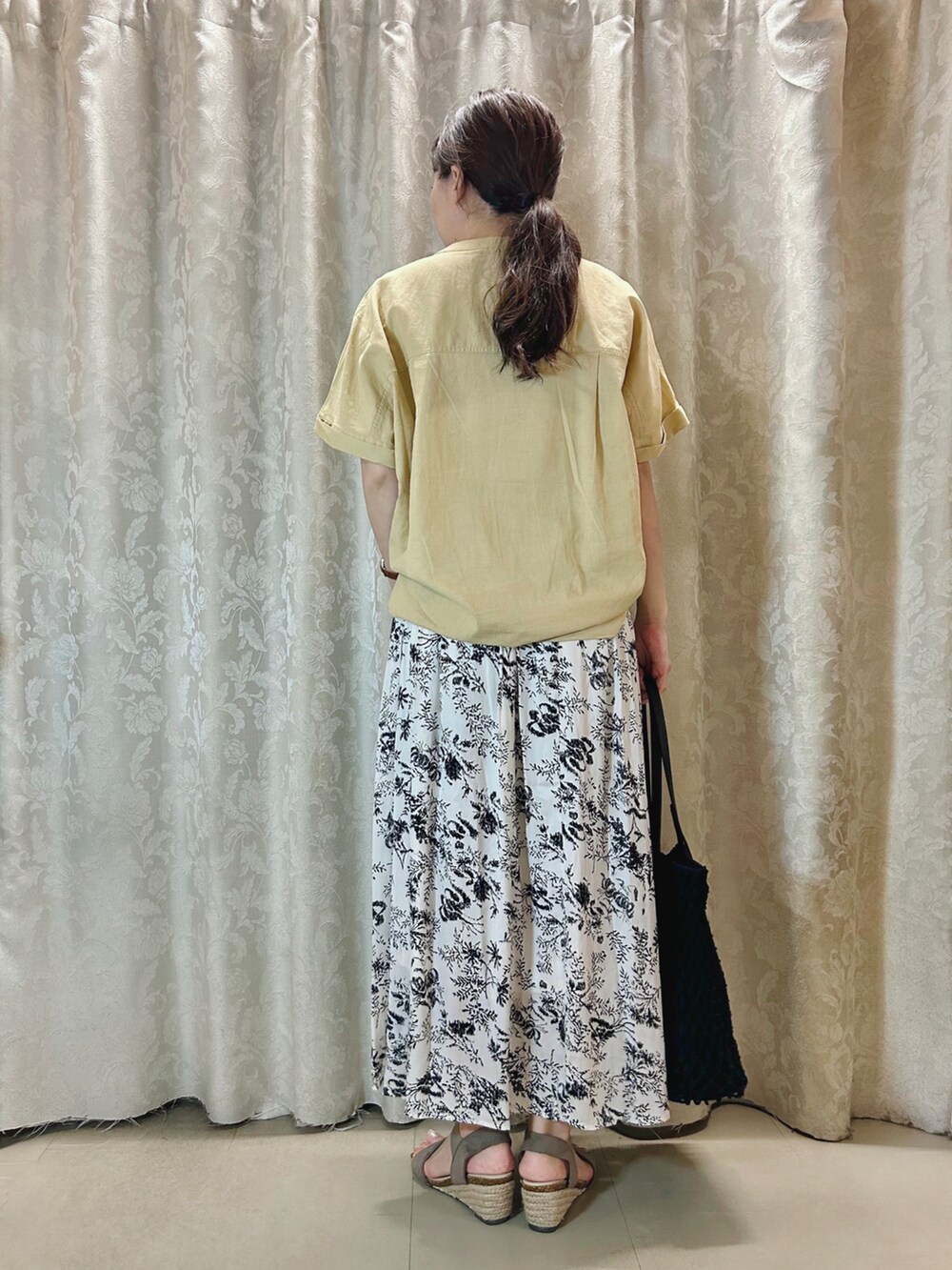 イエロー系のシャツ/ブラウス、ブラック系のトートバッグ、ブラウン系のサンダルを着用したレディースの夏コーディネートの3枚目の写真