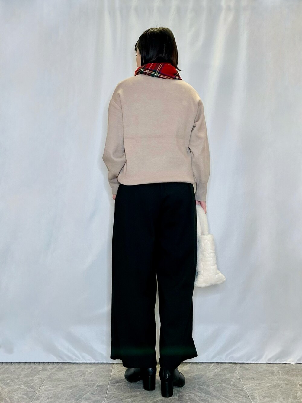 ブラック系のブーツ、ベージュ系のトートバッグ、ベージュ系のニット/セーターを着用したレディースの冬コーディネートの3枚目の写真