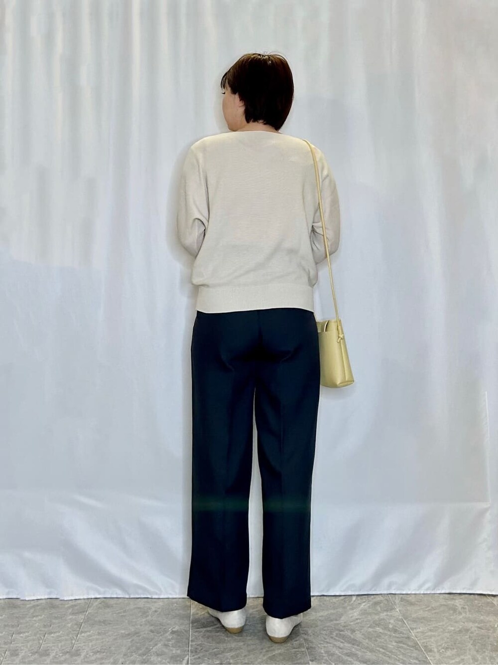 ホワイト系のニット/セーター、グレー系のその他パンツ、ゴールド系のその他シューズを着用したレディースの春コーディネートの3枚目の写真
