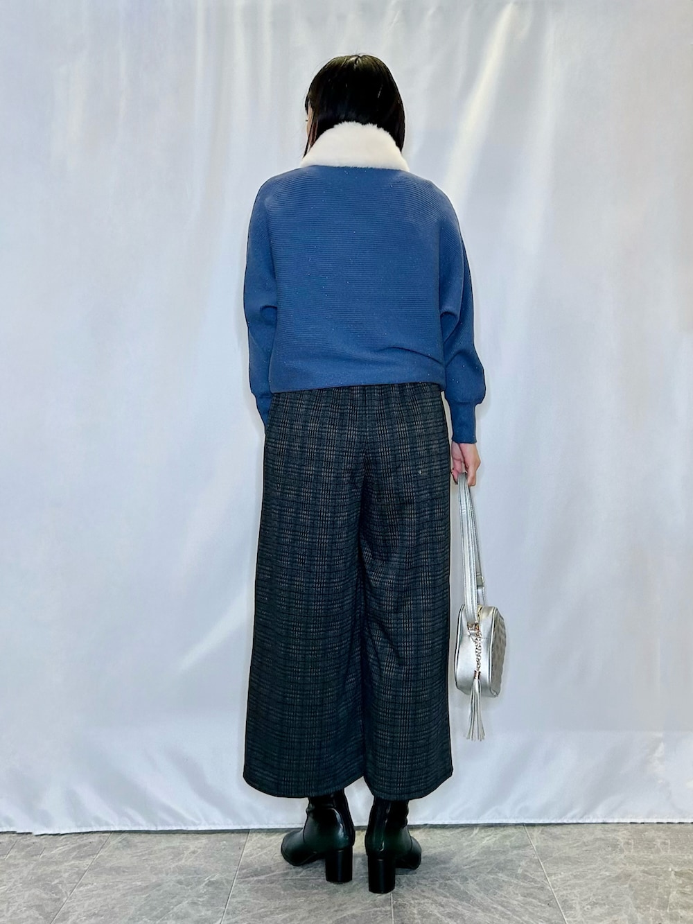 ブラック系のブーツ、グレー系のその他パンツ、シルバー系のショルダーバッグを着用したレディースの冬コーディネートの3枚目の写真