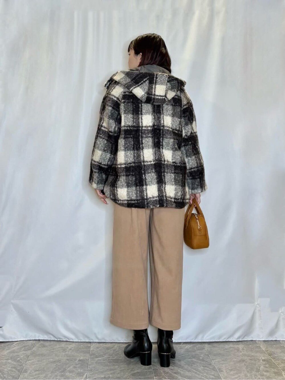 ブラック系のその他アウター、レッド系のTシャツ/カットソー、ブラウン系のその他パンツを着用したレディースの冬コーディネートの3枚目の写真