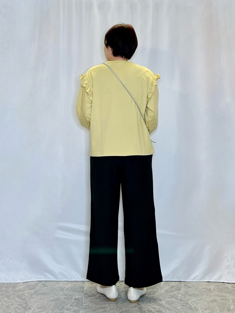 イエロー系のTシャツ/カットソー、ブラック系のその他パンツ、ゴールド系のその他シューズを着用したレディースの春コーディネートの3枚目の写真