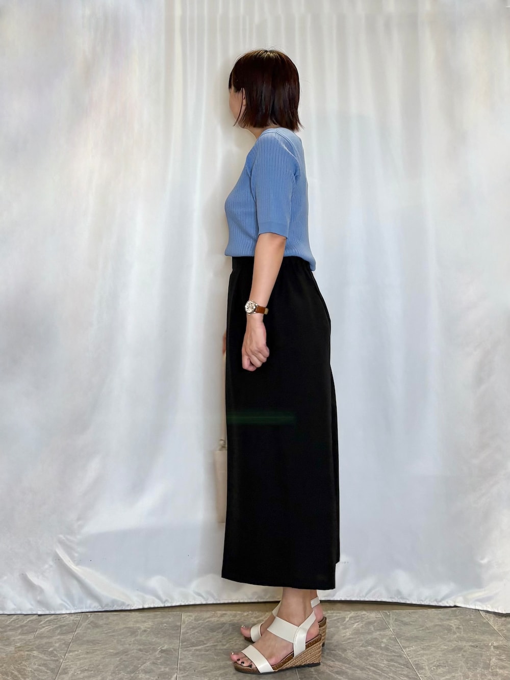 ブルー系のニット/セーター、ブラック系のその他パンツ、ホワイト系のサンダルを着用したレディースの夏コーディネートの4枚目の写真