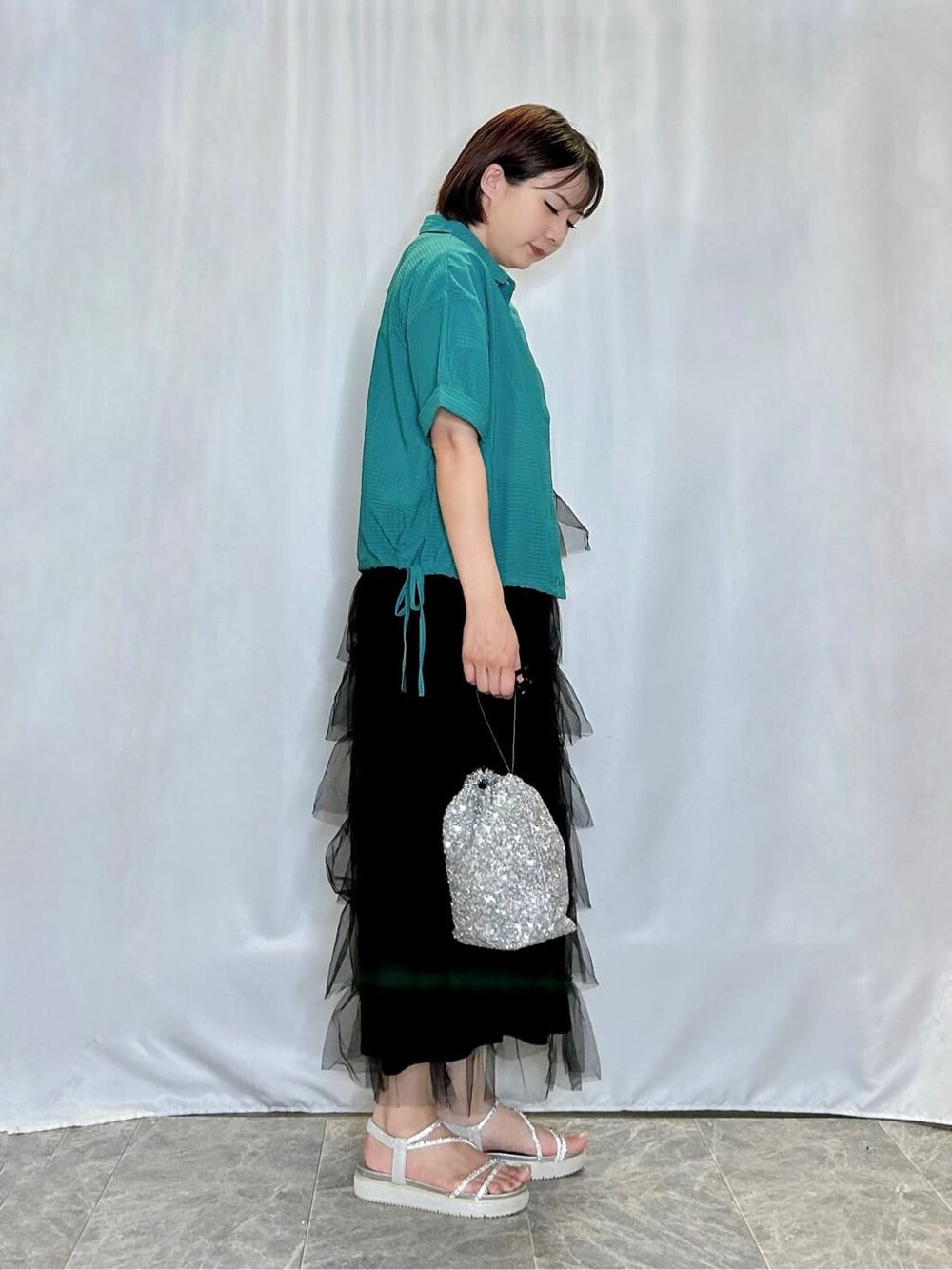 グリーン系のシャツ/ブラウス、ホワイト系のTシャツ/カットソー、ブラック系のスカートを着用したレディースの夏コーディネートの2枚目の写真