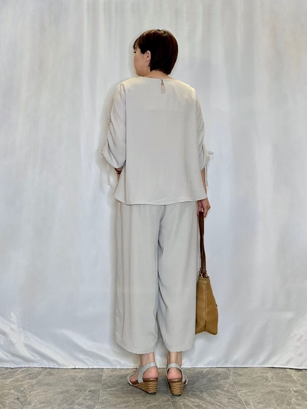 ベージュ系のシャツ/ブラウス、ベージュ系のその他パンツ、シルバー系のサンダルを着用したレディースの春コーディネートの3枚目の写真