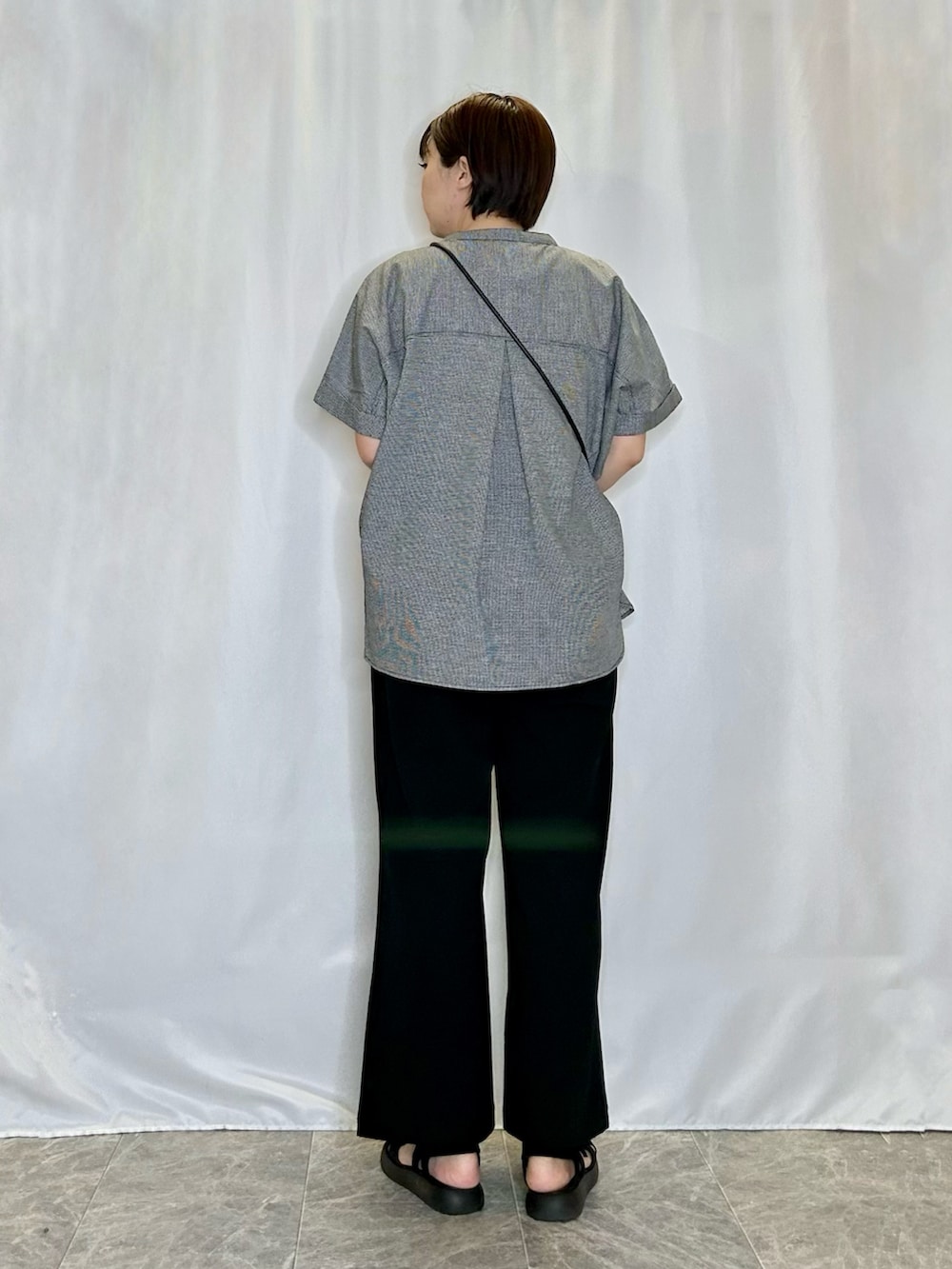 ブラック系のシャツ/ブラウス、ブラック系のショルダーバッグ、ブラック系のサンダルを着用したレディースの春コーディネートの3枚目の写真