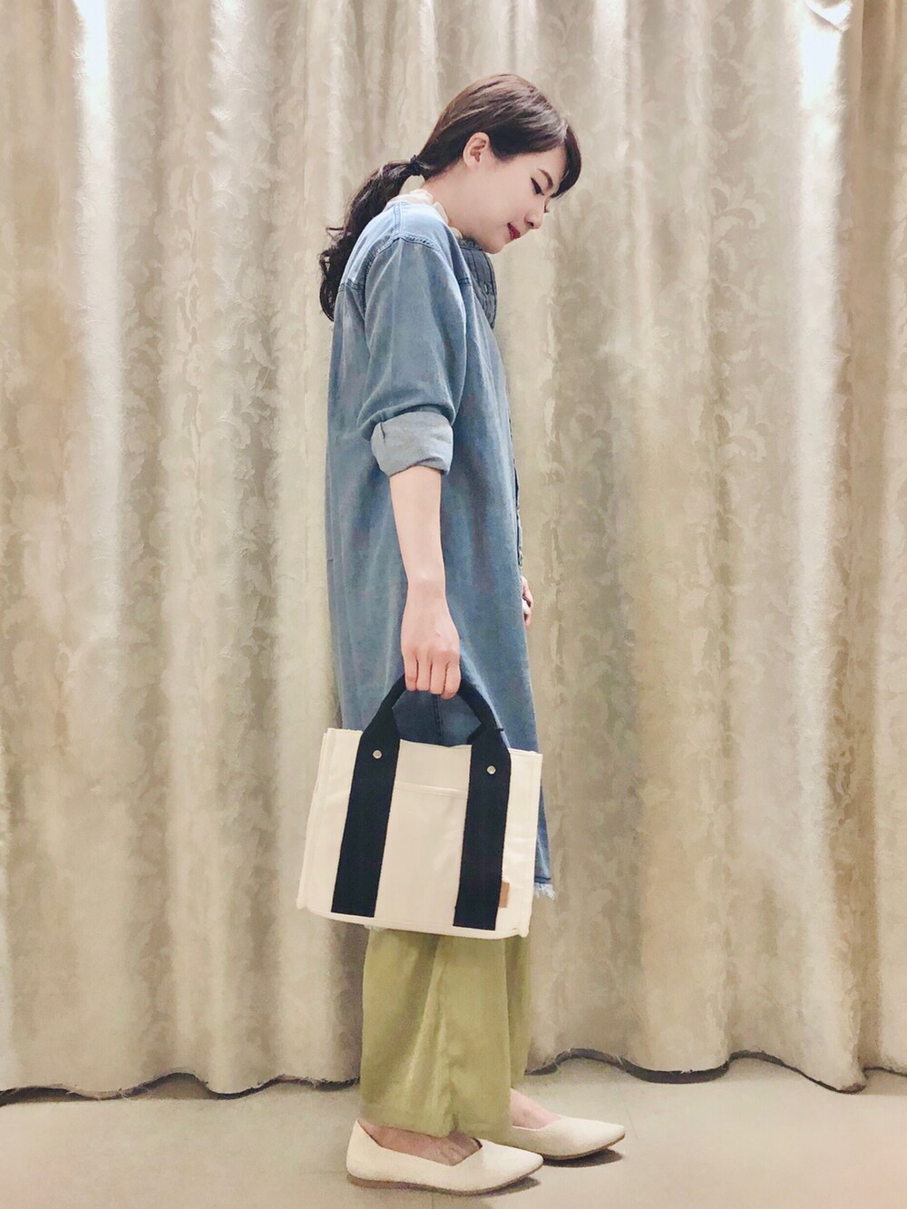 ブルー系のワンピース、ブラック系のトートバッグ、ベージュ系のパンプスを着用したレディースの春コーディネートの2枚目の写真