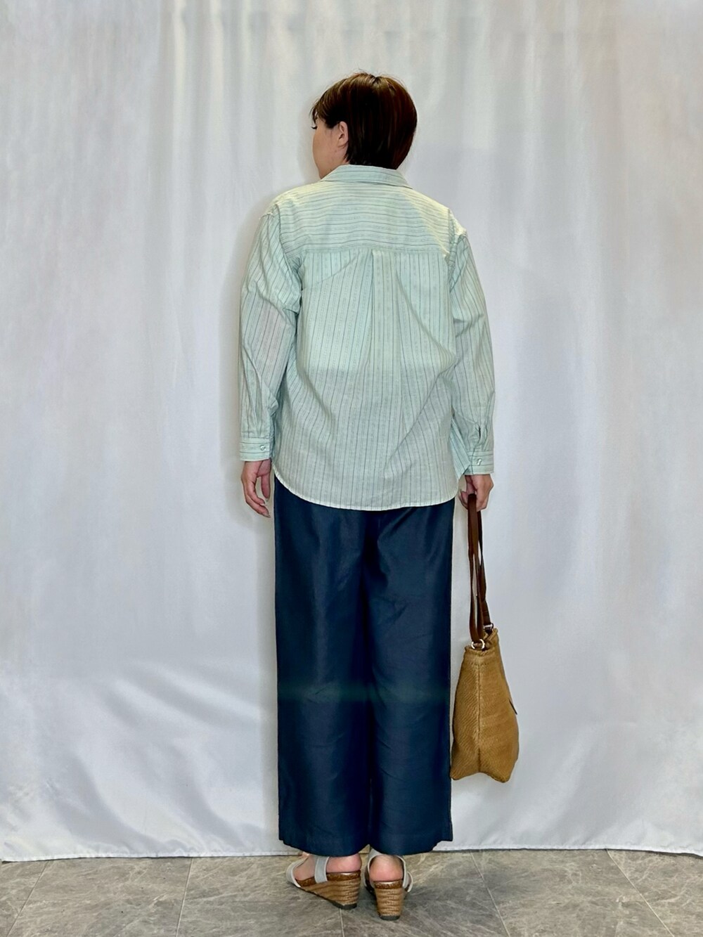 ベージュ系のショルダーバッグ、シルバー系のサンダル、ブルー系のその他パンツを着用したレディースの春コーディネートの3枚目の写真