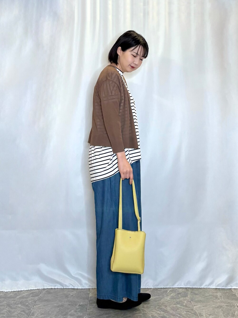 ブラウン系のカーディガン/ボレロ、ホワイト系のTシャツ/カットソー、ブルー系のその他パンツを着用したレディースの春コーディネートの2枚目の写真