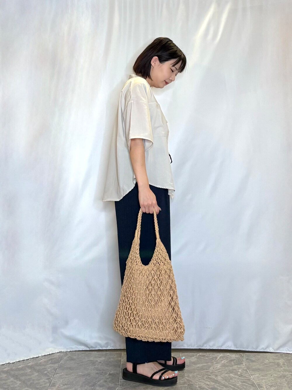 ベージュ系のシャツ/ブラウス、ホワイト系のタンクトップ、ブラック系のサンダルを着用したレディースの夏コーディネートの3枚目の写真