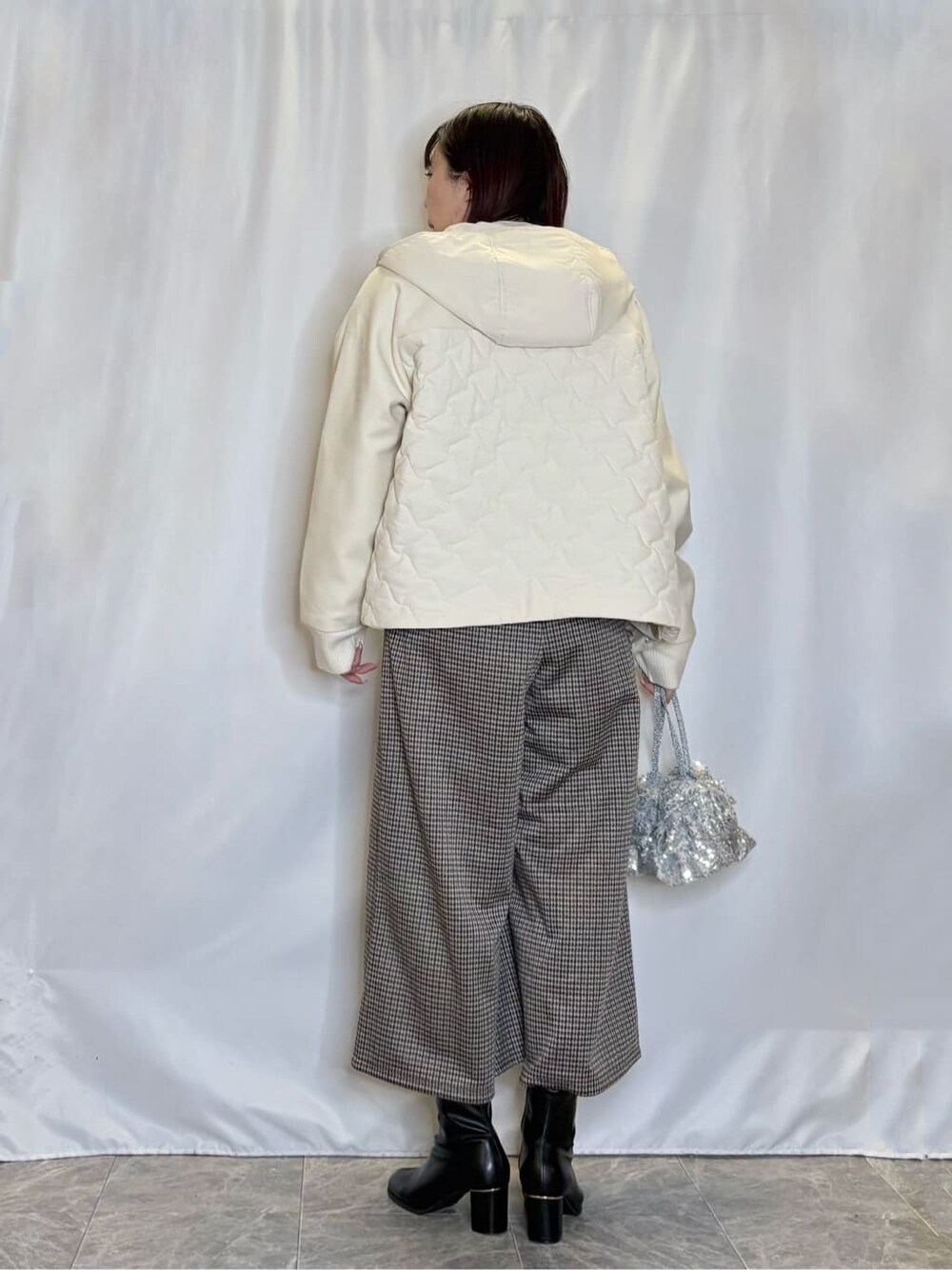 ホワイト系のブルゾン、ブルー系のニット/セーター、ブラウン系のその他パンツを着用したレディースの冬コーディネートの3枚目の写真