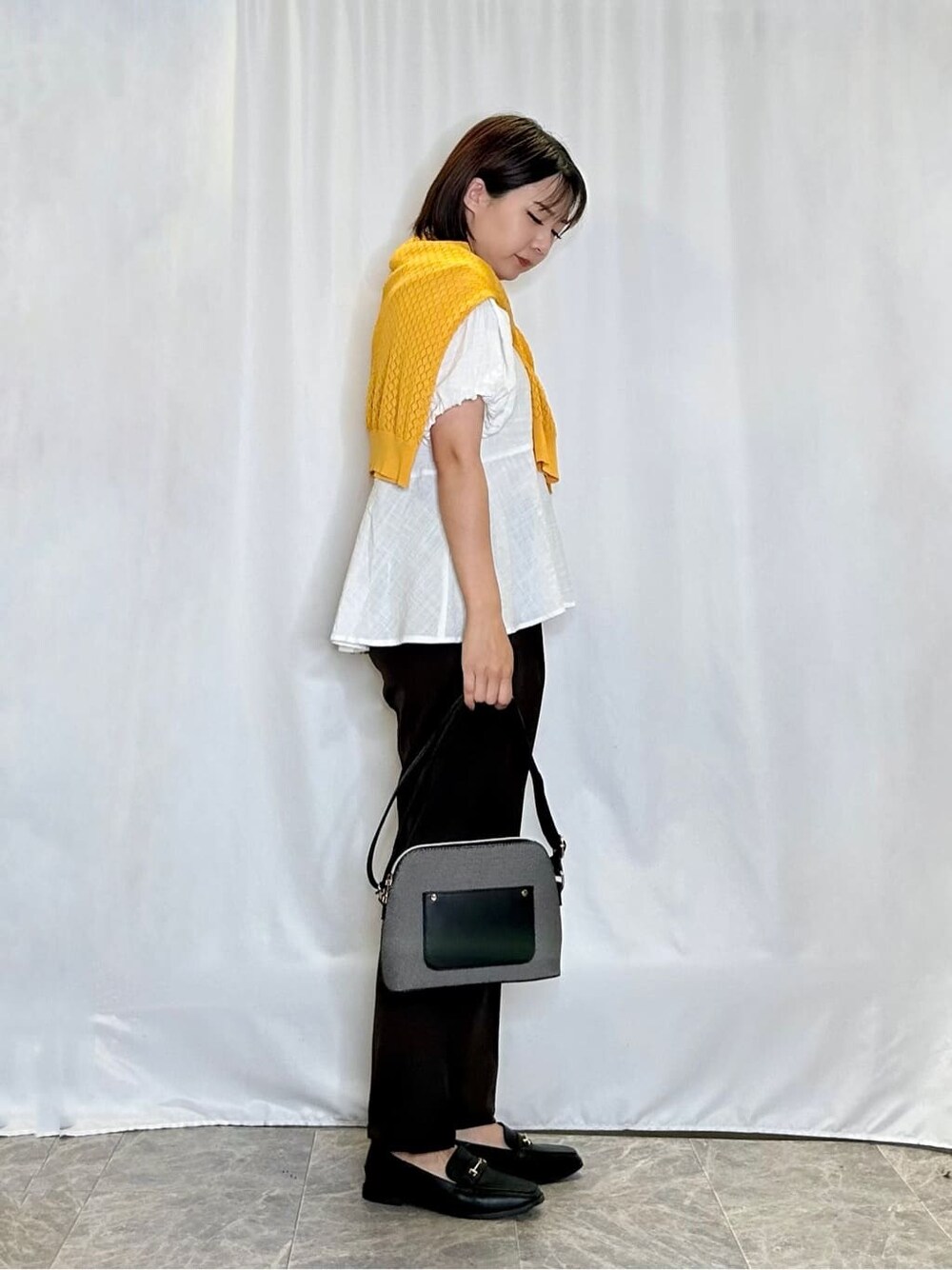 イエロー系のカーディガン/ボレロ、ホワイト系のシャツ/ブラウス、ブラウン系のその他パンツを着用したレディースの夏コーディネートの2枚目の写真