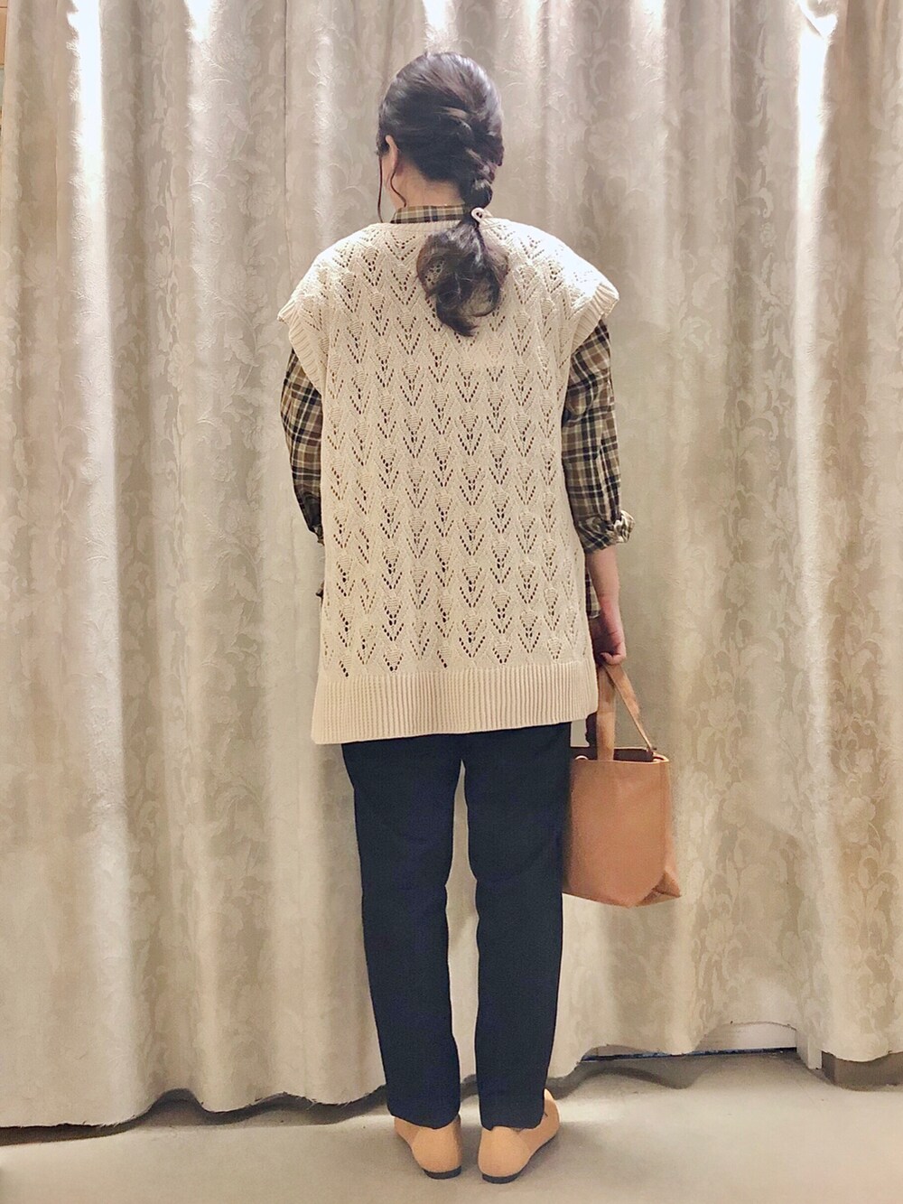 イエロー系のパンプス、ブラック系のその他パンツ、ベージュ系のベストを着用したレディースの秋コーディネートの3枚目の写真