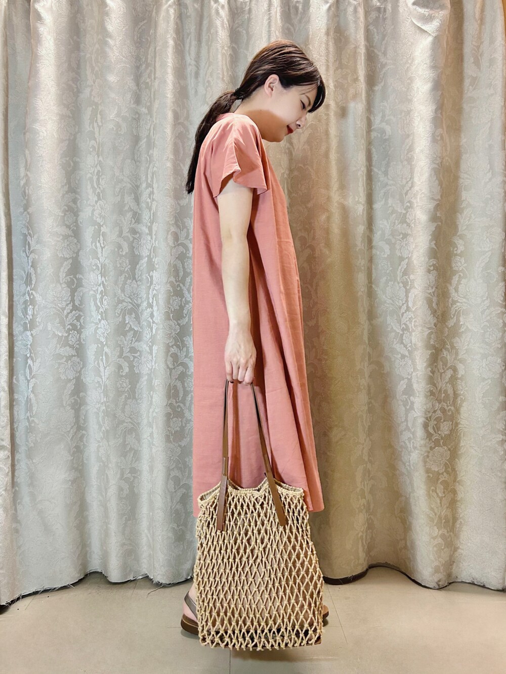 ピンク系のワンピース、ブラウン系のトートバッグ、その他のサンダルを着用したレディースの夏コーディネートの2枚目の写真