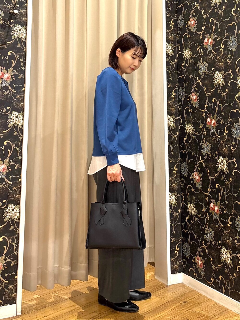 ブルー系のTシャツ/カットソー、グレー系のその他パンツ、ブラック系のトートバッグを着用したレディースの秋コーディネートの2枚目の写真